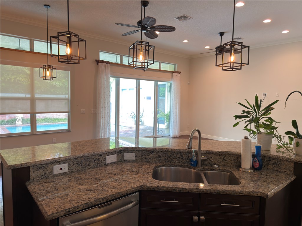4253 Diamond Square Vero Beach, FL 32967 - Photo 6 of 22 a kitchen with kitchen island granite countertop a sink a counter top space and cabinets