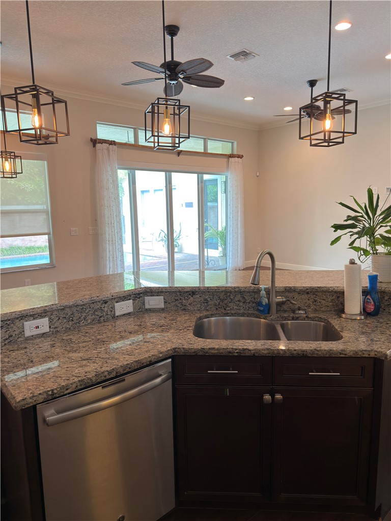 4253 Diamond Square Vero Beach, FL 32967 - Photo 7 of 22 a kitchen with kitchen island granite countertop a sink and chandelier