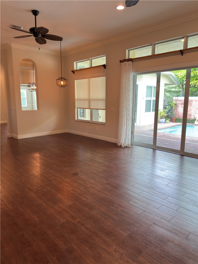 4253 Diamond Square Vero Beach, FL 32967 - Photo 9 of 22 a view of an empty room with wooden floor and a window