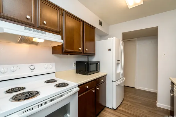 a kitchen with a sink cabinets and wooden floor