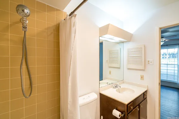 an empty room with wooden floor and a ceiling fan