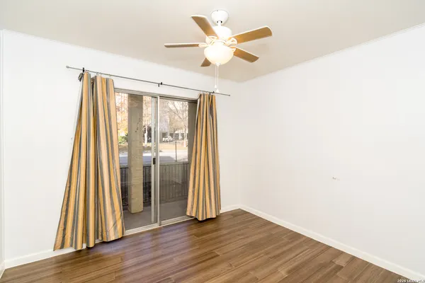 a view of a room with wooden floor and a ceiling fan