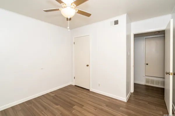 an empty room with wooden floor and a fireplace