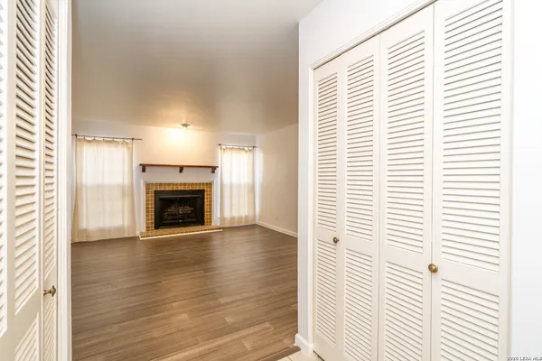a view of an empty room with a window and fireplace
