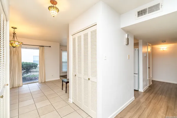 a view of a hallway with wooden floor and a bathroom