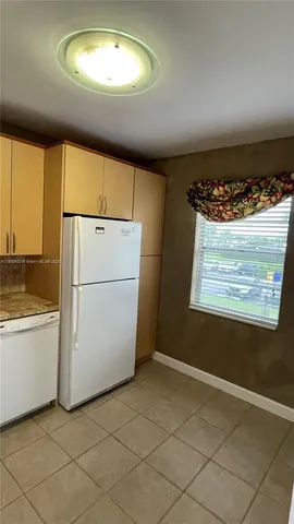 a kitchen with a stove a sink dishwasher and a refrigerator
