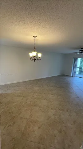 a view of a livingroom with a chandelier fan and window
