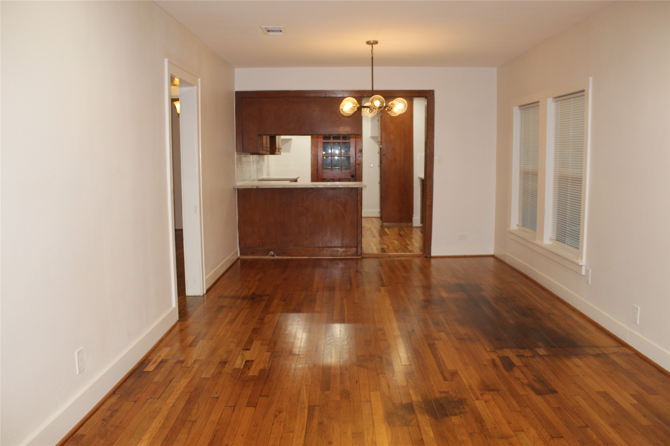 2713 Cochran Street Houston, TX 77009 - Photo 8 of 28 a view of a hallway with wooden floor and a kitchen
