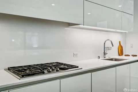 a close view of sink a stove and cabinets