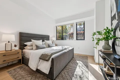 a bedroom with bed plant and window