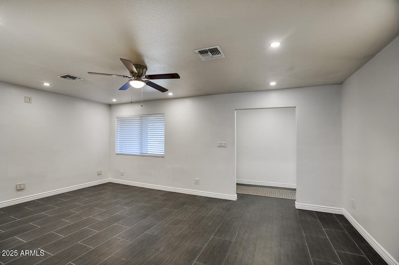 1881 East Concorda Drive Tempe, AZ 85282 - Photo 2 of 15 an empty room with wooden floor and a ceiling fan