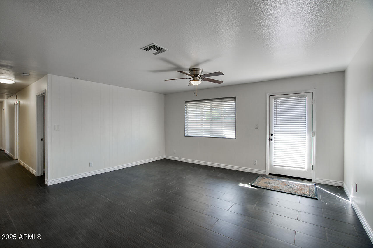 1881 East Concorda Drive Tempe, AZ 85282 - Photo 3 of 15 a view of an empty room with a window and wooden floor