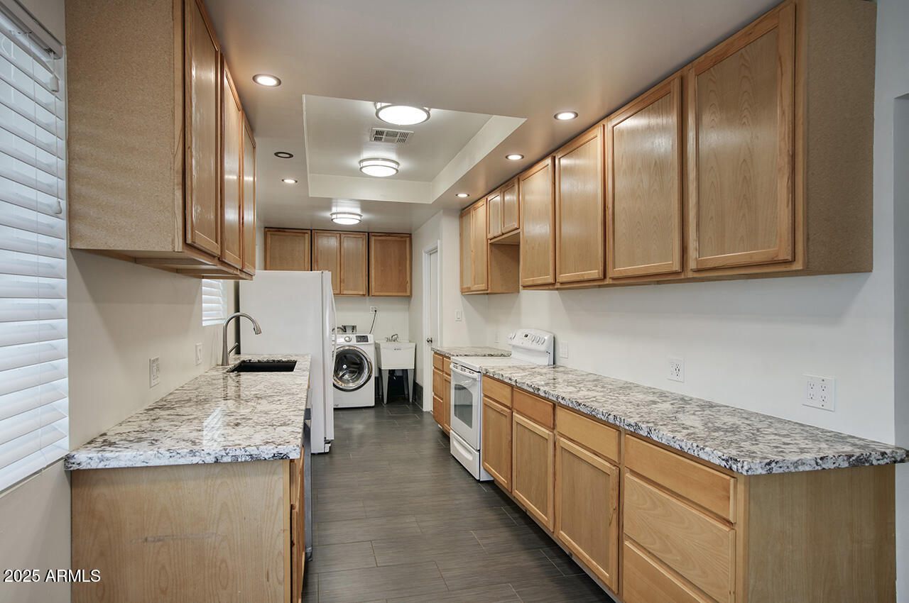 1881 East Concorda Drive Tempe, AZ 85282 - Photo 4 of 15 a kitchen with stainless steel appliances granite countertop a sink and cabinets