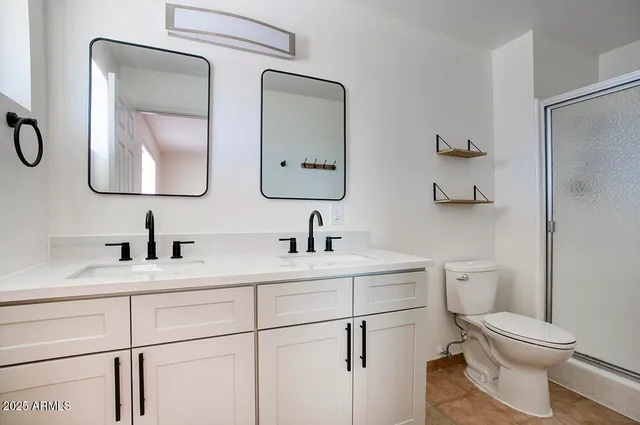 a bathroom with a toilet sink vanity and mirror