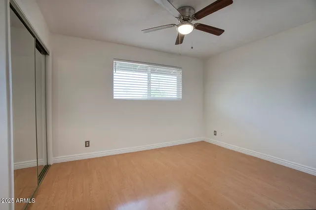 an empty room with a window and a fan