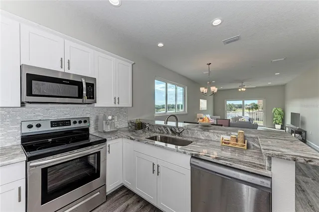 a kitchen with a sink stove and microwave