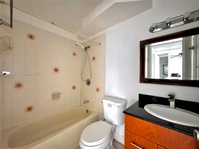 a bathroom with a granite countertop sink toilet a mirror and shower