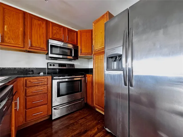 a kitchen with stainless steel appliances granite countertop a refrigerator microwave and stove top oven