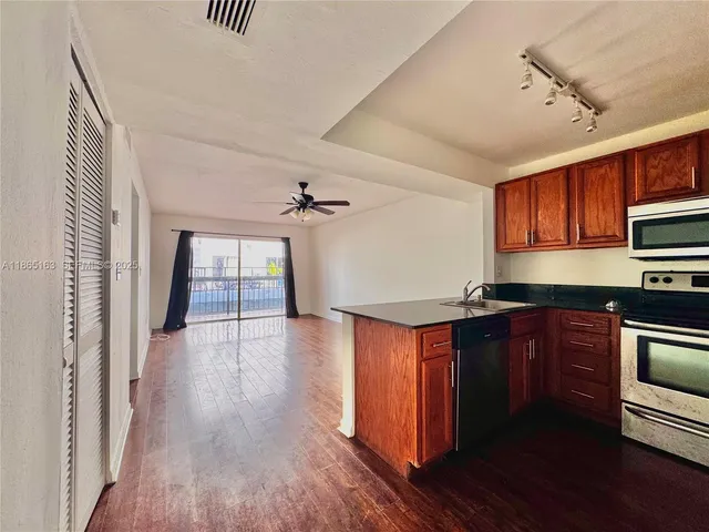 a kitchen with granite countertop wooden floors and stainless steel appliances