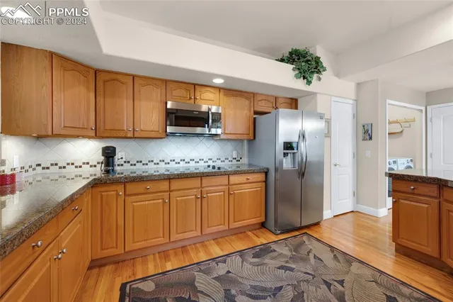 a kitchen with stainless steel appliances granite countertop a refrigerator sink and cabinets