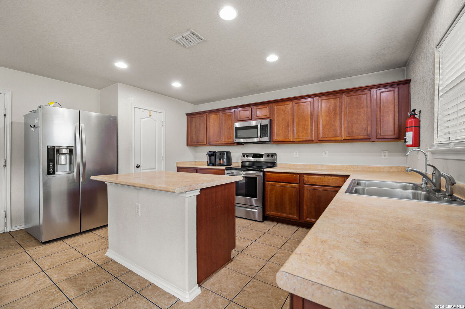 7207 Avery Road Live Oak, TX 78233 - Photo 17 of 32 a kitchen with stainless steel appliances granite countertop a stove a sink and a refrigerator