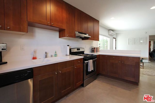 a kitchen with stainless steel appliances granite countertop a sink a stove and cabinets