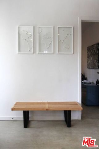 a bench sitting in a kitchen with white walls