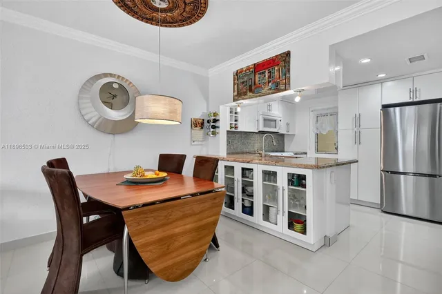 a kitchen with stainless steel appliances granite countertop a stove a refrigerator a oven a sink with a dining table and chairs