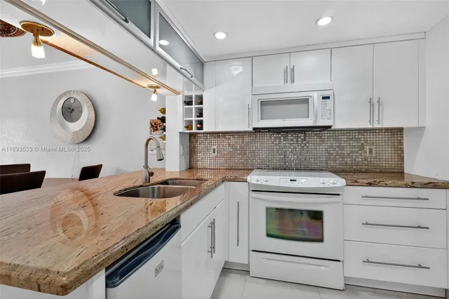 a kitchen with granite countertop a sink a stove and cabinets