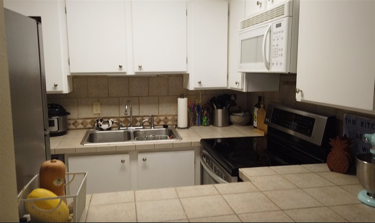 3740 Lower Honoapiilani Road, Unit B103 Lahaina, HI 96761 - Photo 4 of 16 a kitchen with stainless steel appliances granite countertop a sink stove and cabinets