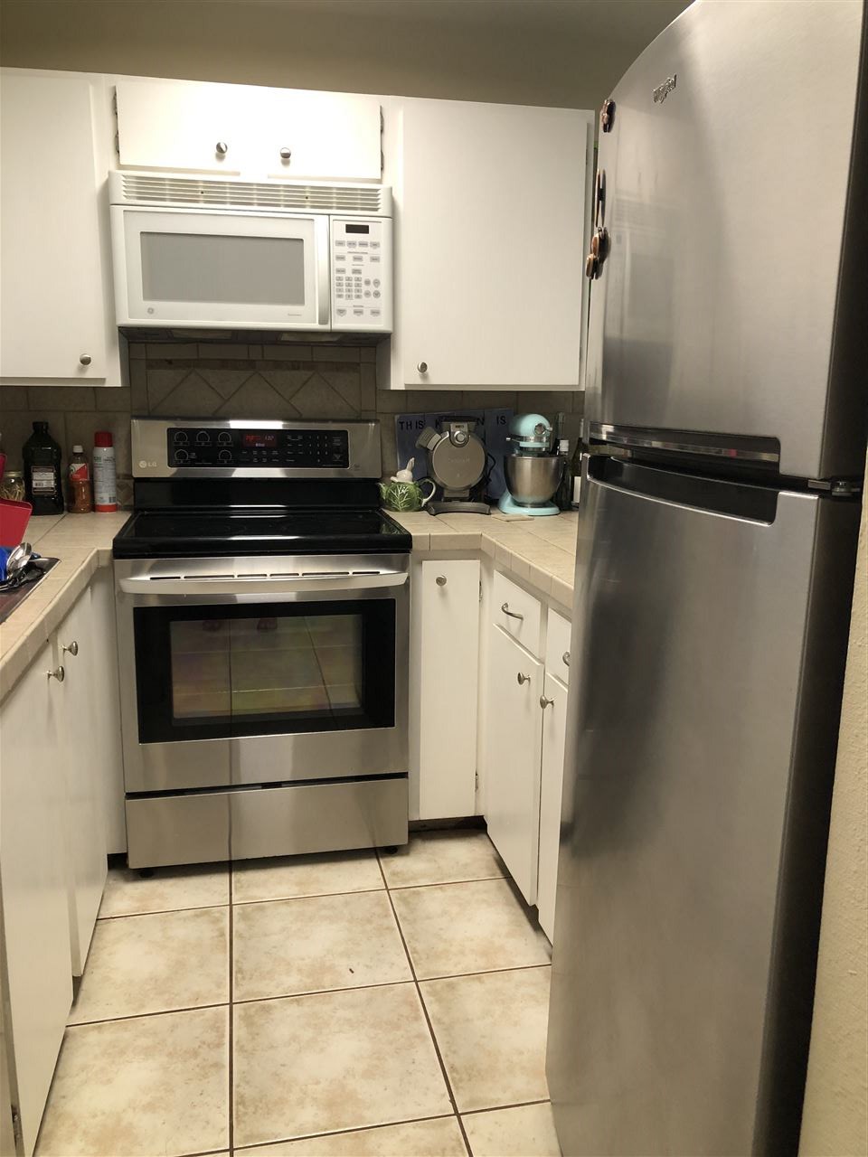 3740 Lower Honoapiilani Road, Unit B103 Lahaina, HI 96761 - Photo 5 of 16 a kitchen with a stove a sink and a refrigerator