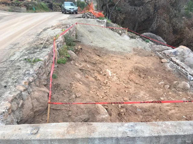 a view of a yard with wooden fence