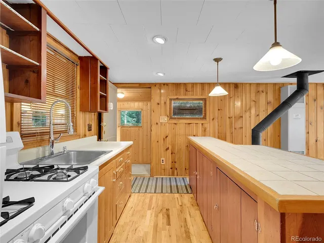 a kitchen with stainless steel appliances granite countertop sink stove and refrigerator