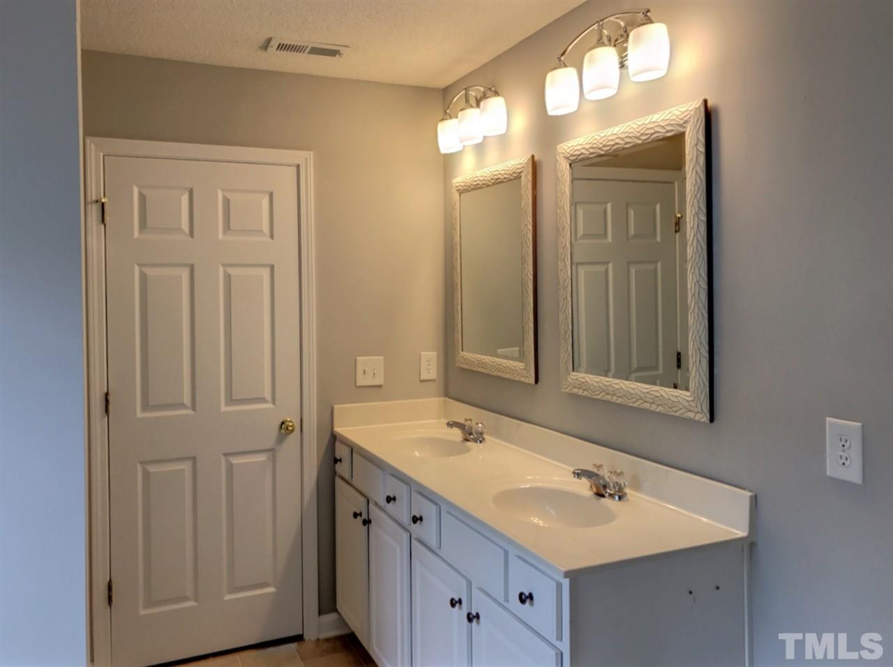 208 Rapp Lane Apex, NC 27502 - Photo 15 of 16 a bathroom with a double vanity sink and a mirror