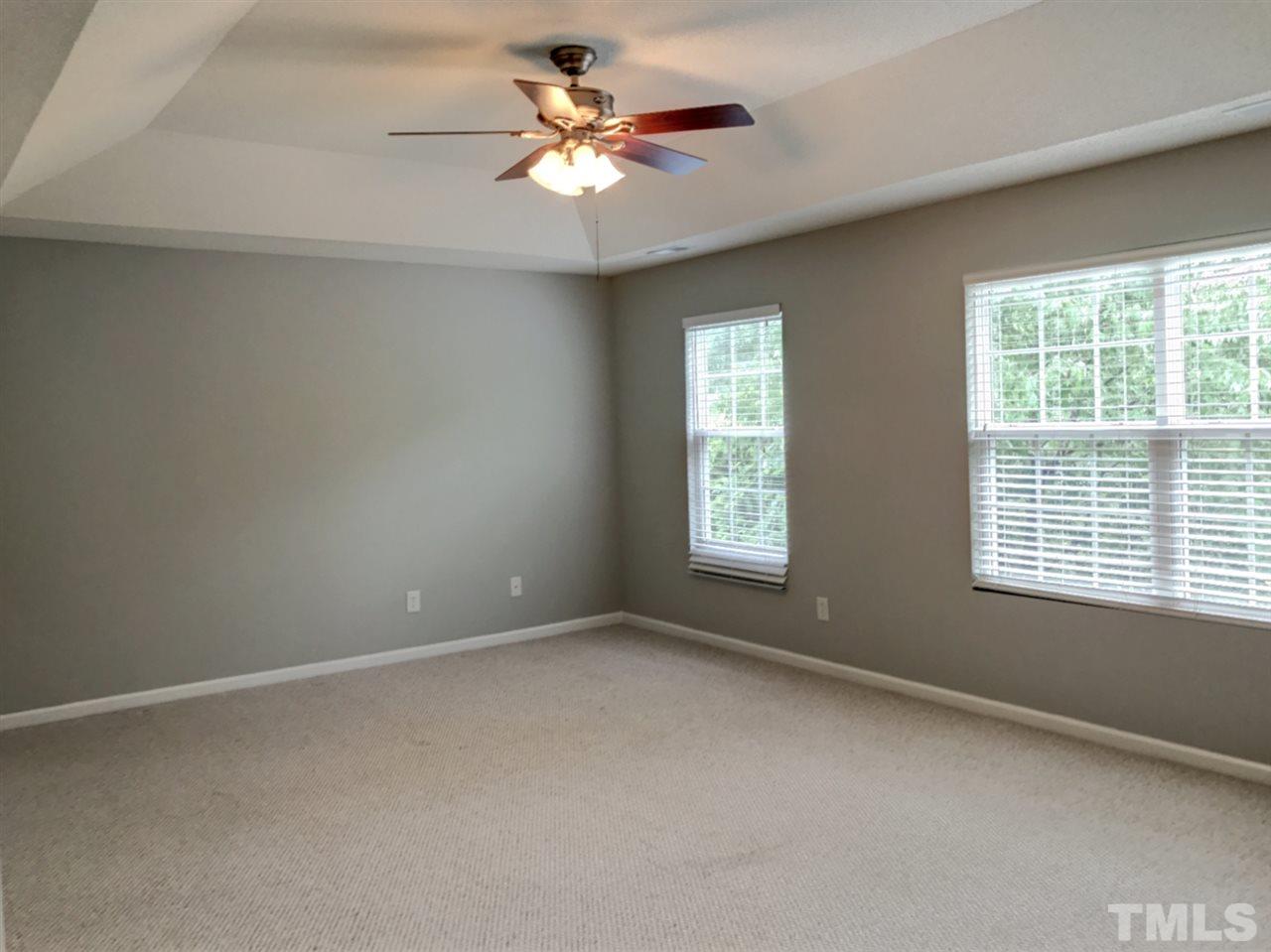 208 Rapp Lane Apex, NC 27502 - Photo 16 of 16 an empty room with windows and chandelier fan