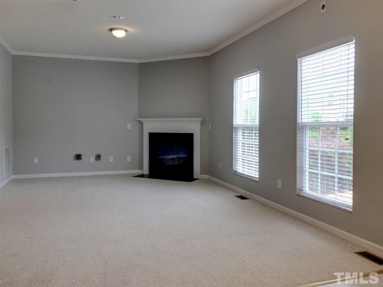 208 Rapp Lane Apex, NC 27502 - Photo 3 of 16 a view of an empty room with a fireplace and a window