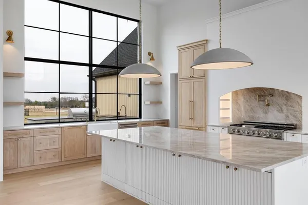 a kitchen with stainless steel appliances granite countertop a stove a sink and a refrigerator