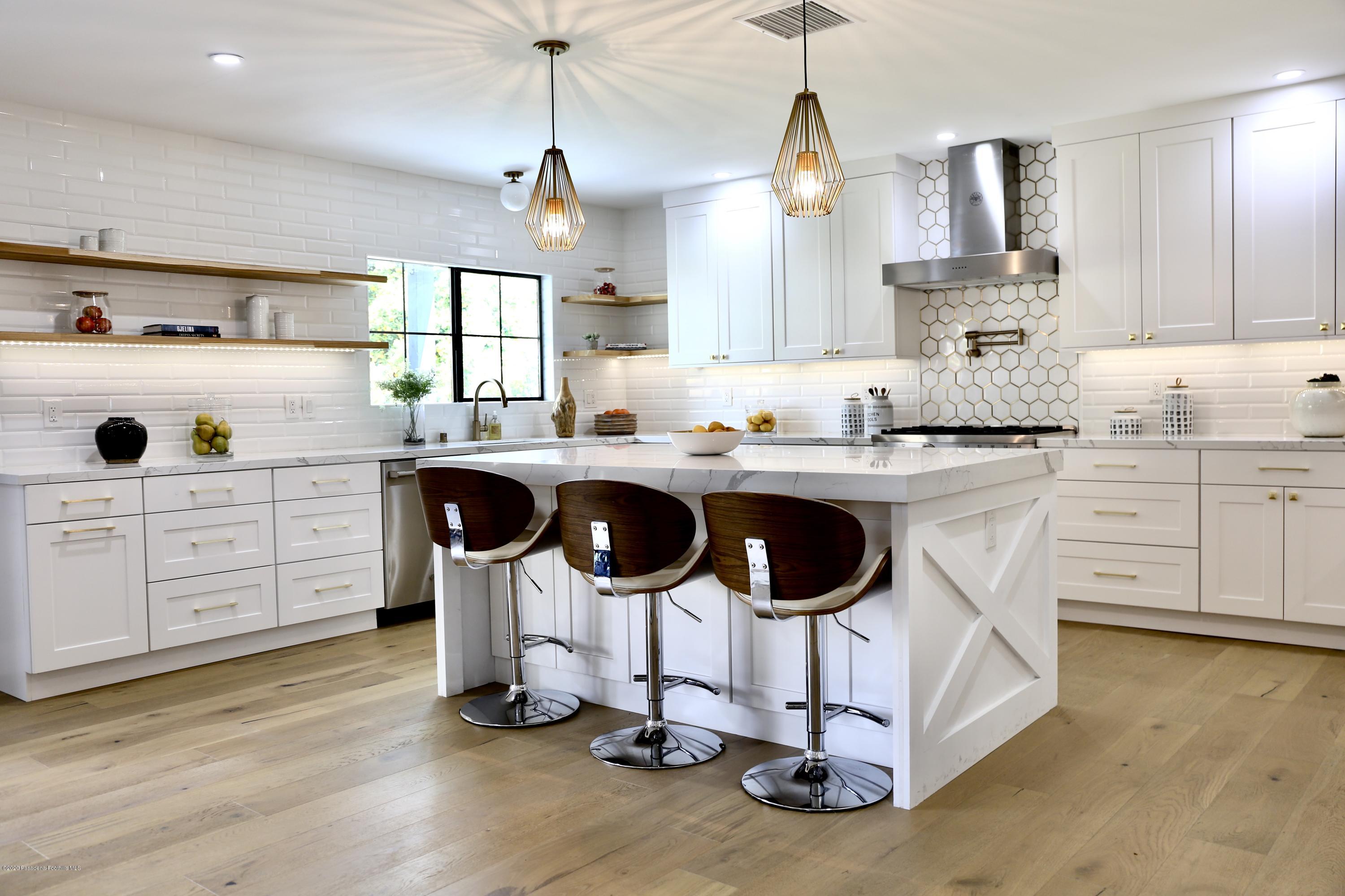 3665 Thorndale Road Pasadena, CA 91107 - Photo 17 of 45 a kitchen with kitchen island granite countertop a sink a stove and chairs with wooden floor