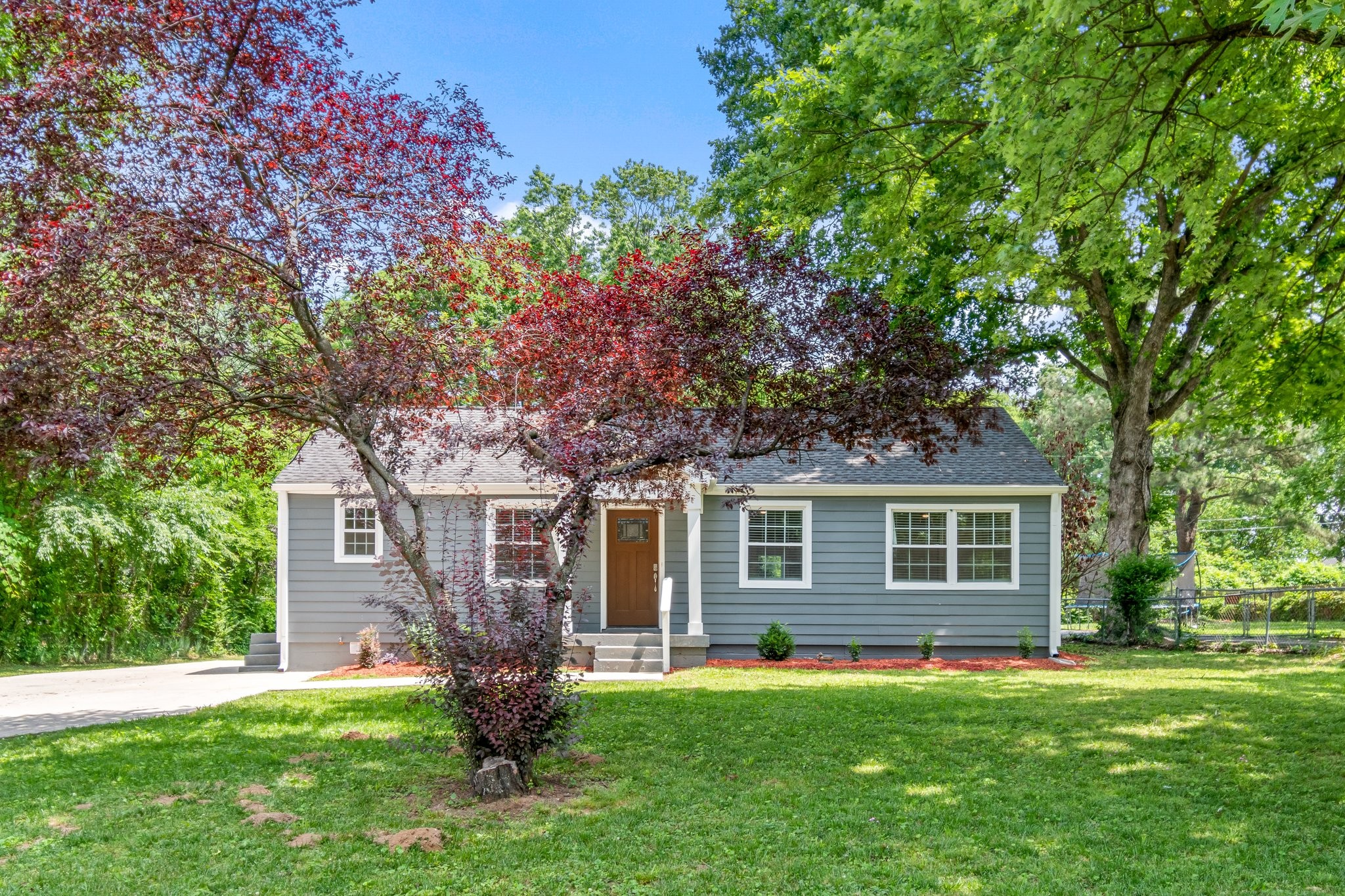 884 Kipling Drive Nashville, TN 37217 - Photo 5 of 40 a front view of a house with a garden and trees