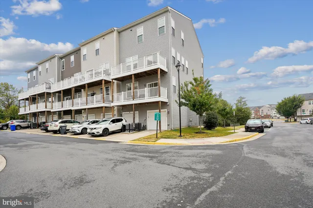a view of tall building with small yard and large trees