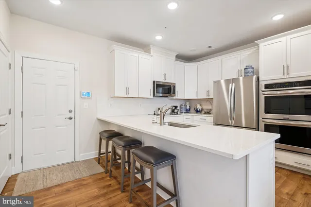 a kitchen with a sink a microwave a refrigerator and cabinets