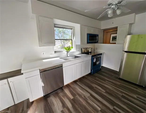 a kitchen with white cabinets and white appliances