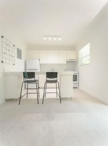a view of cabinets with stainless steel appliances wooden floor and chair