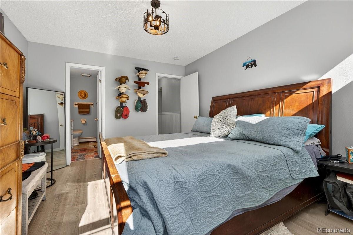 11827 Brook Road Golden, CO 80403 - Photo 13 of 32 a bedroom with a bed and wooden floor