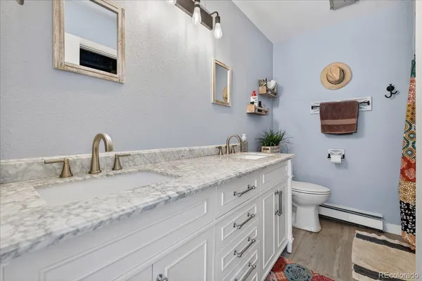 a bathroom with a granite countertop toilet sink and mirror