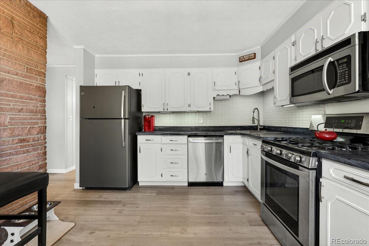 11827 Brook Road Golden, CO 80403 - Photo 7 of 32 a kitchen with stainless steel appliances a stove a microwave and a refrigerator