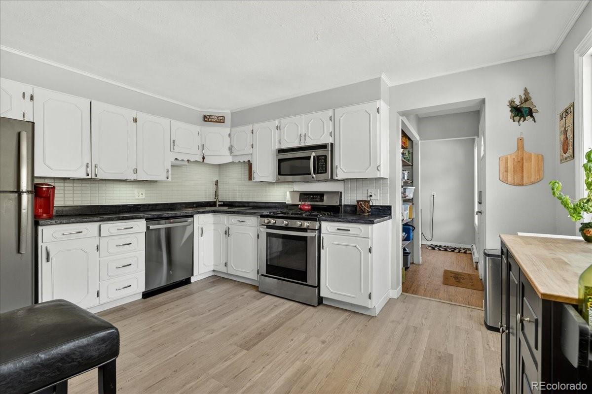 11827 Brook Road Golden, CO 80403 - Photo 8 of 32 a kitchen with granite countertop white cabinets and white appliances