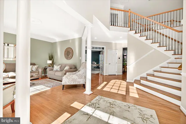 a living room with furniture a clock on wall and a window