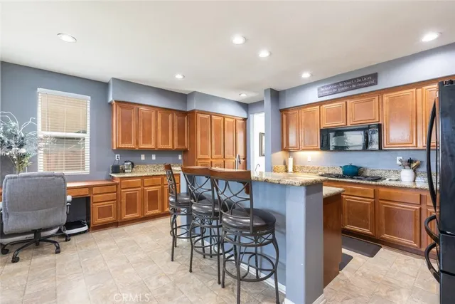 a kitchen with stainless steel appliances granite countertop sink stove top oven table and chairs