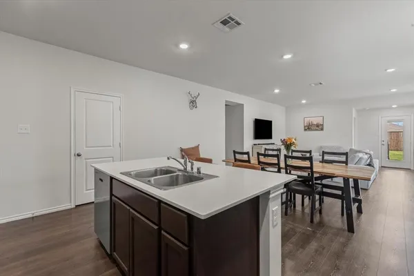 a kitchen with stainless steel appliances granite countertop a sink a microwave and chairs